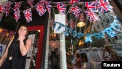 Employee Hayley Simmonds reacts as she celebrates the news that Britain's Catherine, Duchess of Cambridge, has given birth to a son, outside the British themed restaurant Tea & Sympathy in New York, Jul. 22, 2013.