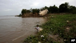 FILE - A Cambodian fisherman takes off his fishing net at Mekong river bank of Koh Norea village in Phnom Penh, Cambodia.