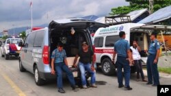 Ambulance workers wait to transport the bodies of the victims of the crashed Trigana Air Service flight at Sentani airport in Jayapura, Papua province, Indonesia, Aug. 18, 2015. 