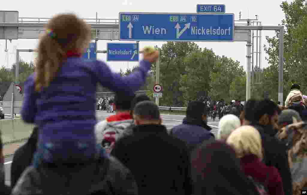 Migrants walk on the highway A4 toward Vienna after crossing the Hungarian-Austrian border near Nickelsdorf, Austria.