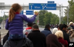 Migrants walk on the highway A4 toward Vienna after crossing the Hungarian-Austrian border near Nickelsdorf, Austria, Sept. 11, 2015.