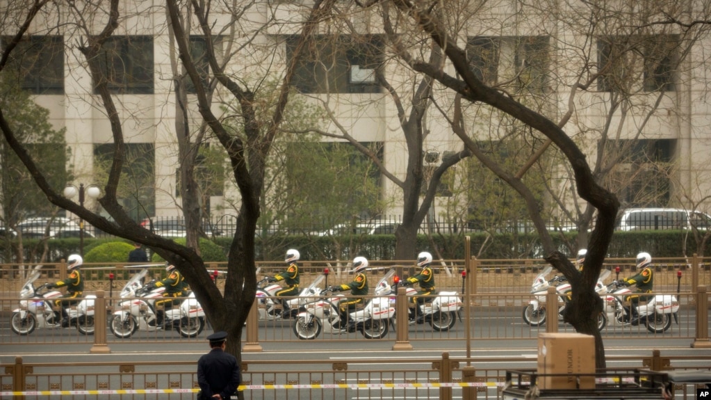 Guardias en motocicleta escoltan una caravana en Beijing, a lo largo de la avenida Chang'an, una de las mÃ¡s importantes de la capital china.