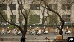 Guardias en motocicleta escoltan una caravana en Beijing, a lo largo de la avenida Chang'an, una de las más importantes de la capital china.