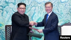 Predsednik Južne Koreje Mun Džae-in i lider Severne Koreje Kim Džong Un rukuju se u demilitarizovanoj zoni
