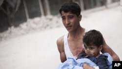 Một thanh niên bế một em bé bị thương sau vụ pháo kích của quân đội Syria gần bệnh viện Dar El Shifa, Aleppo, Syria 11.10.2012.