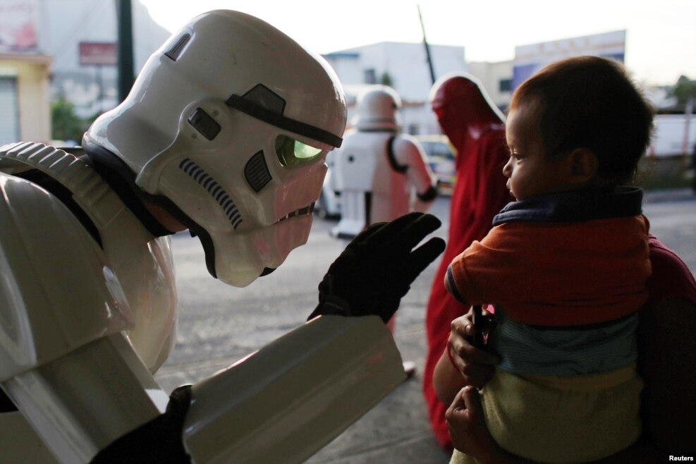 A member of the Star Wars fan club, dressed as a Stormtrooper, talks to a girl outside a hospital's emergency ward during Star Wars Day celebrations in Monterrey, Mexico on May 4, 2016.