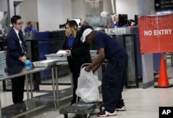 An employee of the Chef Creole restaurant, right, unloads meals for TSA workers at Miami International Airport, Jan. 15, 2019, in Miami.