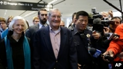 Merrill Newman, center, walks beside his wife Lee after arriving at San Francisco International Airport on Saturday, Dec. 7, 2013. 