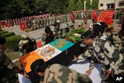 Indian Border Security Force officers carry the coffin of colleague Sushil Kumar who was killed in firing from the Pakistan side of the border, during a wreath-laying ceremony in Jammu, India, Oct. 24, 2016.