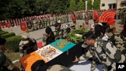 Indian Border Security Force officers carry the coffin of colleague Sushil Kumar who was killed in firing from the Pakistan side of the border, during a wreath-laying ceremony in Jammu, India, Oct. 24, 2016. 