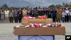 FILE - Pakistani military officials and others offer prayers for victims of a helicopter crash prior to their transport to Islamabad, at the Gilgit airport, in the Gilgit-Baltistan region of Pakistan, May 9, 2015. 
