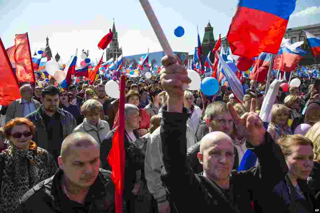 Russians wave flags and cheer as they walk on Red Square to mark May Day in Moscow, Russia, May 1, 2016. As in Soviet times, cheerful workers paraded across Red Square but instead of red flags with the Communist hammer and sickle, they waved the blue flag