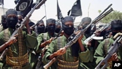 FILE PHOTO - Al-Shabab fighters march with their guns during military exercises on the outskirts of Mogadishu on March 4, 2012.