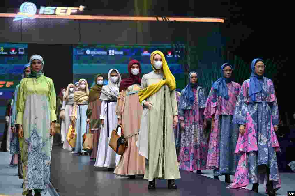 Modelos exibem criações durante um desfile de moda muçulmano no Festival Económico Sharia da Indonésia em Jacarta em 28 de Outubro de 2021.