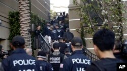 FILE - Federal agents enter upscale apartment complex where authorities say a birth tourism business charged pregnant women $50,000 for lodging, food and transportation, Irvine, Calif., March 3, 2015.