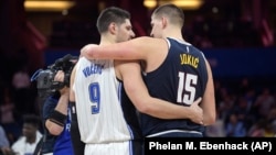 Le pivot d'Orlando Magic, Nikola Vucevic, à gauche, et son vis-à-vis des Denver Nuggets, Nikola Jokic , après un match à Orlando, en Floride, le 5 décembre 2018.