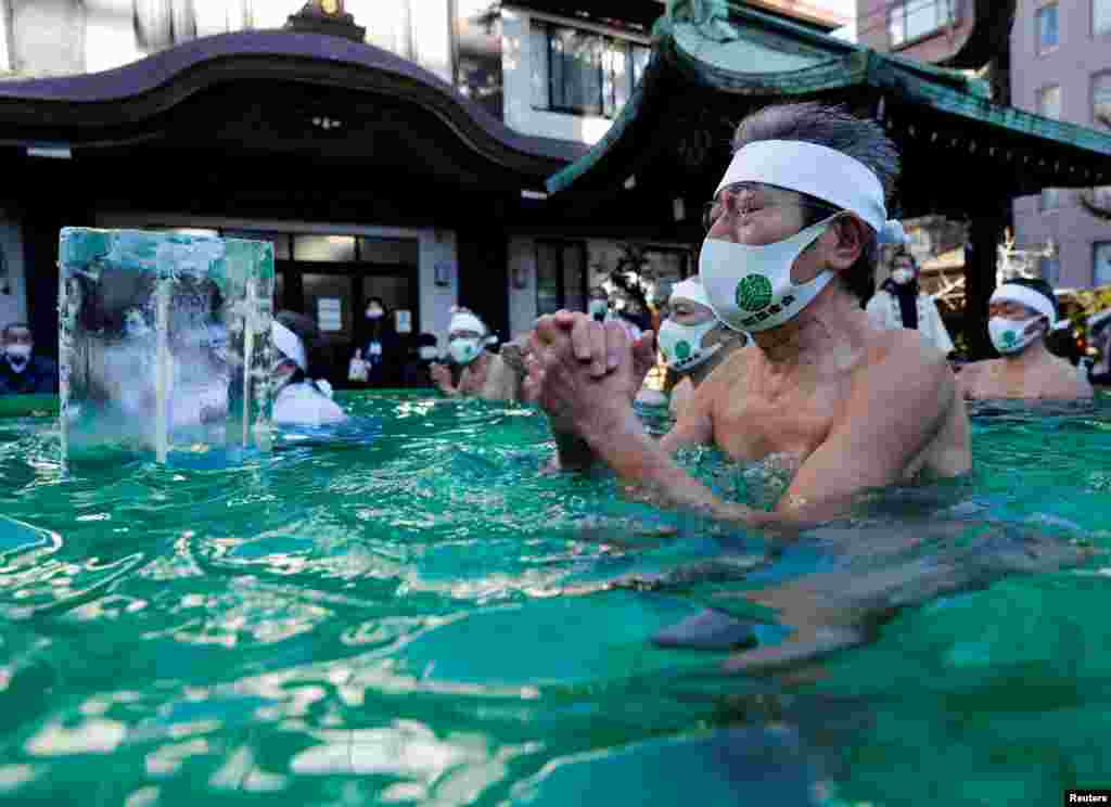 Participants pray as they take an ice-cold bath during a ceremony to purify their souls and to wish for overcoming the COVI-19 pandemic at the Teppozu Inari shrine in Tokyo, Japan.