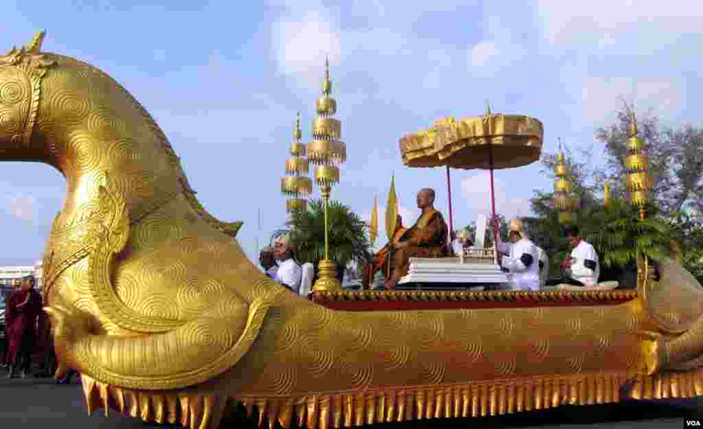 柬埔寨两位佛教高僧之一坐在皇家车驾上引导把西哈努克国王灵柩从机场送往皇宫的送丧行列。