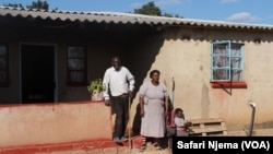 Sandiforo Banda of Tsvanhu village in Domboshava, standing proudly in front of his five-bedroomed house, with is wife and niece. 