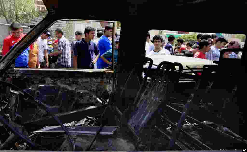 People gather at the scene of a car bomb attack in the Sadr City neighborhood in Baghdad, May 16, 2013.