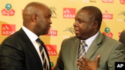 FILE - Kirsten Nematandani, president of the South African Football Association (R) shakes hands with then coach for South Africa's national soccer team Pitso Mosimane, in Johannesburg, South Africa, July 15, 2010.