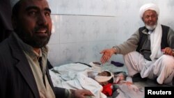 Relatives grieve over the bodies of children who were killed during fighting in Ghazni, Afghanistan, Jan. 26, 2018.