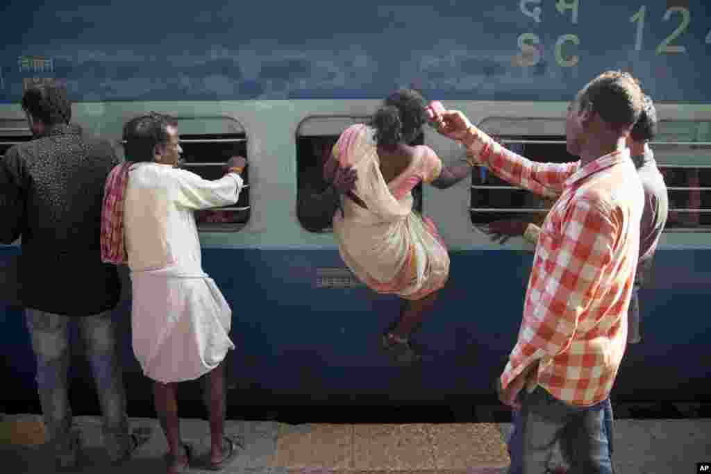 بعد از پایان یک جشنواره در شمال هند، مسافران در حال بازگشت هستند و این زن هندی سعی دارد از پنجره به زور وارد قطار شود.