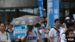 有香港市民帶同寫上標語的雨傘，冒著雷暴警告、大驟雨及超過攝氏30度的高溫天氣參與毅行爭普選活動 (美國之音湯惠芸拍攝)