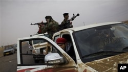 Libyan rebel fighters wait inside their cars before going to the front line, on the outskirts of Ajdabiya, April 20, 2011