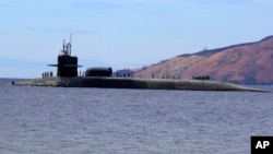 FILE - A U.S. Navy crew stands on the USS Michigan, an Ohio-class guided-missile submarine, as it prepares to dock at Subic Freeport, a former US naval base west of Manila, Philippines, March 25, 2014. The sub was on a routine port call. 