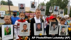 Фото: родичі з портретами військових, які загинули у військовому конфлікті з підтримуваними Росією силами на сході України, під час акції біля посольства Росії в Україні, 28 серпня 2020 року