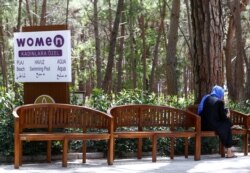 Seorang tamu duduk di dekat tanda yang menunjukkan tempat untuk perempuan di Wome Deluxe Hotel, resor liburan yang ramah dan halal, di Alanya, Turki, 18 April 2018. (REUTERS/Osman Orsal)