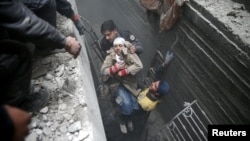 22일 시리아 동구타 지역에서 구조여원들이 부상자를 이송하고 있다.