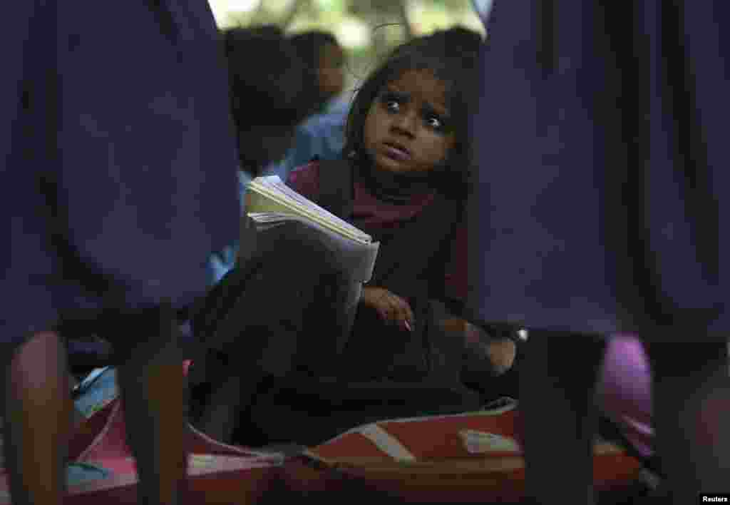 نئی دہلی میں کھلے آسمان تلے بچے تعلیم حاصل کرتے ہوئے