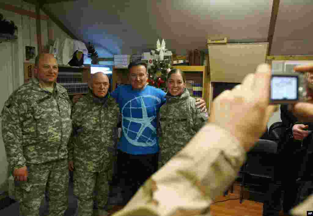 Komedian AS Robin Williams, ketiga dari kiri, berpose bersama prajurit AS di pangkalan AS di Kabul, Afghanistan, 20 Desember 2007. Sekitar 500 prajurit Amerika menonton bintang USO tampil dalam badai salju.