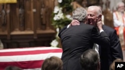 El expresidente George W. Bush abraza al exsecretario de Estado James Baker (derecha), después del panegírico de Baker al expresidente George H.W. Bush en la iglesia episcopal de San Martín, en Houston, Texas.