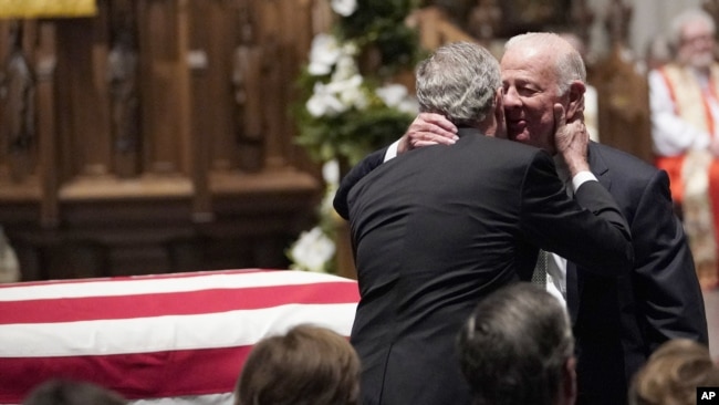 El expresidente George W. Bush abraza al exsecretario de Estado James Baker (derecha), después del panegírico de Baker al expresidente George H.W. Bush en la iglesia episcopal de San Martín, en Houston, Texas.