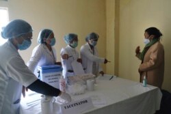 FILE - Nurse Shimray Wungreichon, 43, speaks to colleagues who will administer her the COVID-19 vaccine at the District Hospital in Ukhrul, in the northeastern Indian state of Manipur, Saturday, Jan. 16, 2021