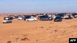 Displaced Libyans from the western city of Tawergha wait by their cars to enter the city, which lies about 250 kilometres east of the capital Tripoli, on Feb. 1, 2018,