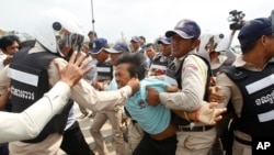 A Worker Union member, Suth Chet, 36, center, is beaten by district security personnel during a protest rally at a blocked street near National Assembly, in Phnom Penh, Cambodia, April 4, 2016.