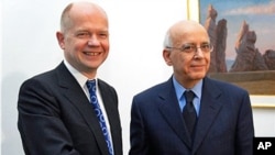Tunisian Prime Minister Mohamed Ghannouchi, right, shakes hands with Britain's Foreign Secretary William Hague during a meeting at Carthage Palace, outside Tunis, February 8, 2011