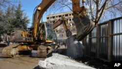 Bulldozers tear down a concrete wall erected in the northern city of Mitrovica on Sunday, Jan. 5, 2017, that has provoked tensions between Kosovo and neighboring Serbia. 