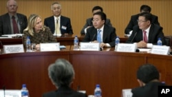 Mongolian President Elbegdori Tsakhia, center, and Mongolian Minister of Foreign Affairs and Trade Gombojav Zandanshatar, right, listen as U.S. Secretary of State Hillary Rodham Clinton delivers the opening remarks to the Community of Democracies Governing Council, at the Ministry of Foreign Affairs Monday, July 9, 2012 in Ulan Bator, Mongolia.