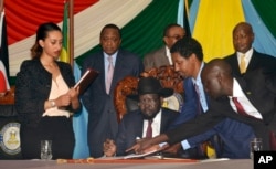 South Sudan President Salva Kiir, seated, signs a peace deal as Kenya’s President Uhuru Kenyatta, center-left, Ethiopia’s Prime Minister Hailemariam Desalegn, center-right, and Uganda’s President Yoweri Museveni, right, look on in Juba, South Sudan, Aug. 26, 2015.