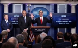 Treasury Secretary Steven Mnuchin, center, joined by National Economic Director Gary Cohn, center, and White House press secretary Sean Spicer speaks in the briefing room of the White House in Washington, April 26, 2017.