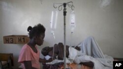 Mgonjwa wa kipindupindu Haiti akihudumiwa na ndugu yake.