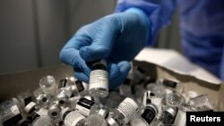 A nurse puts a used Pfizer-BioNTech COVID-19 vaccine vial in a disposal box with empty vials at Messe Wien Congress Center, which has been set up as a coronavirus disease (COVID-19) vaccination centre, in Vienna, Austria February 7, 2021.