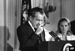 FILE - Richard Nixon performs the last acts of his presidency in the White House East Room, August 9, 1974, as he bids farewell to his Cabinet, aides, and staff.
