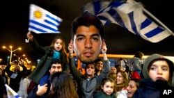 Fans of Uruguay's national soccer team await the arrival of Uruguay player Luis Suarez at Carrasco International Airport in the outskirts of Montevideo, Uruguay, June 26, 2014.