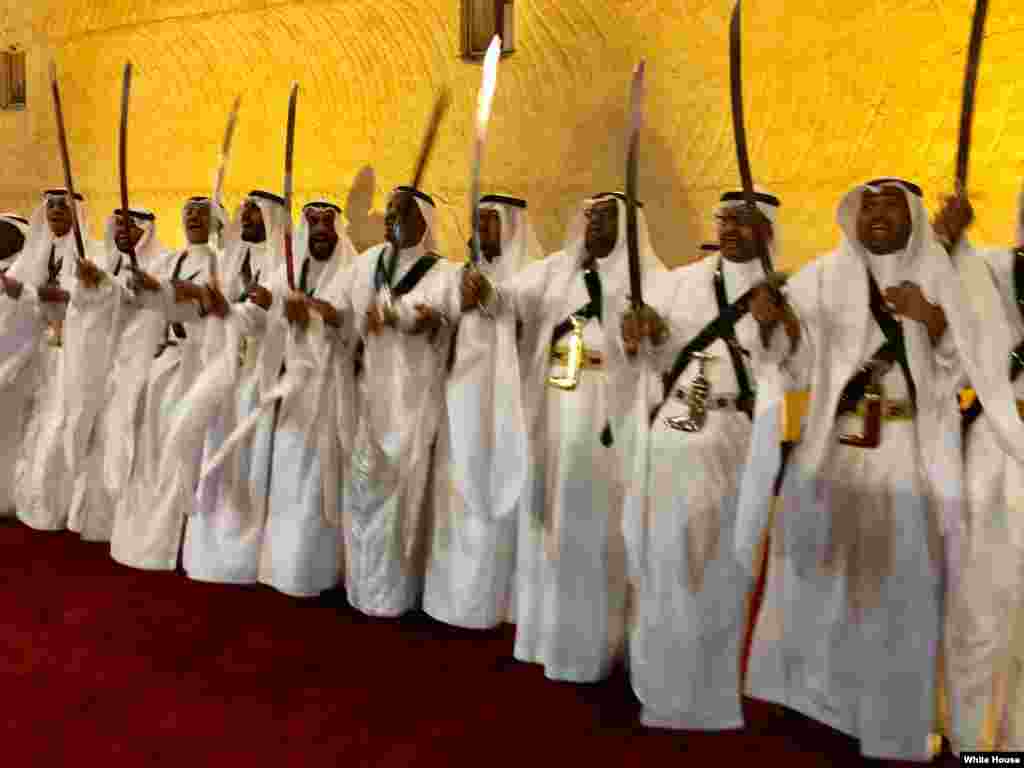 Des Saoudiens en costume traditionnel exécutent une danse avec des épées devant le président Donald Trump et la première dame américaine, Melania Trump, au palais royal, Ryad, 20 mai 2017.